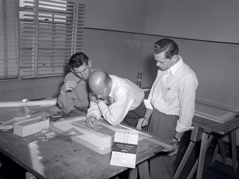  A professor and two students work on an architectural drawing